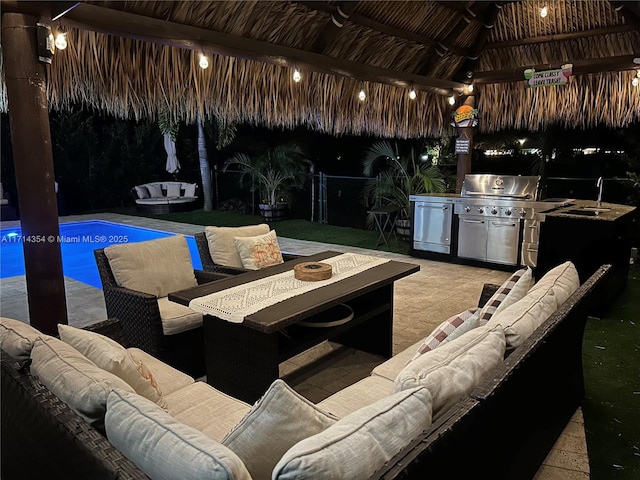 view of patio with area for grilling, a sink, an outdoor living space, a gazebo, and an outdoor pool