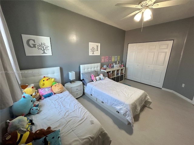 carpeted bedroom with ceiling fan, baseboards, and a closet