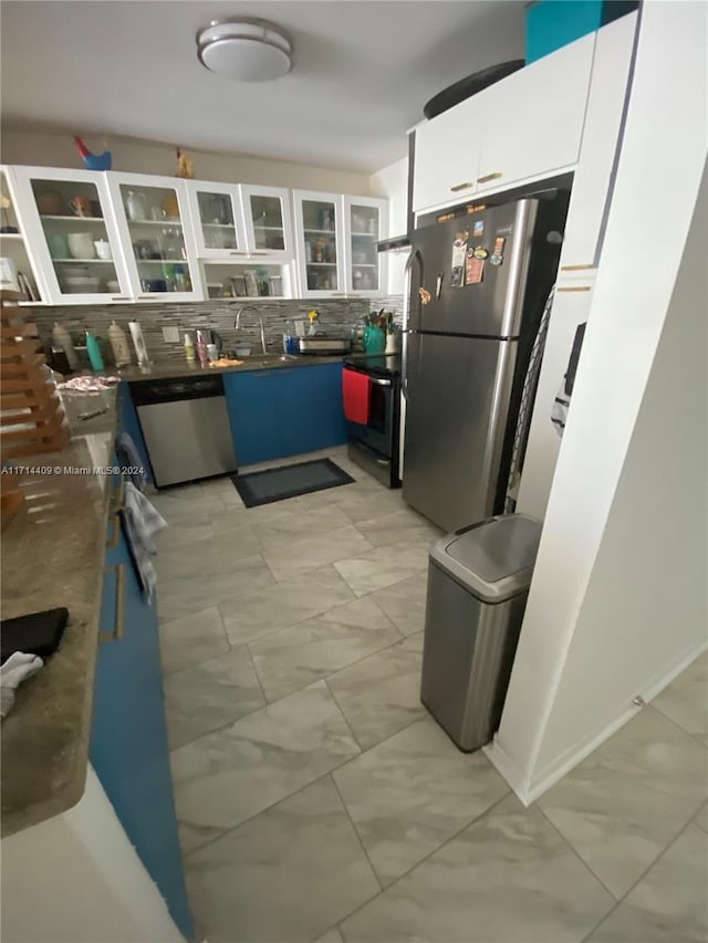 kitchen featuring backsplash, sink, blue cabinetry, appliances with stainless steel finishes, and white cabinetry