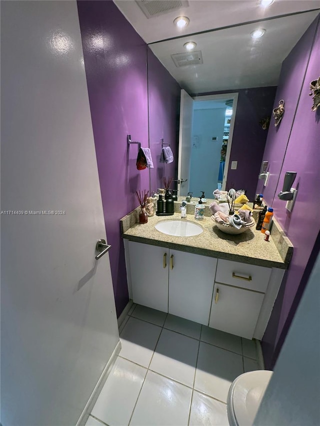 bathroom with tile patterned flooring, vanity, and toilet