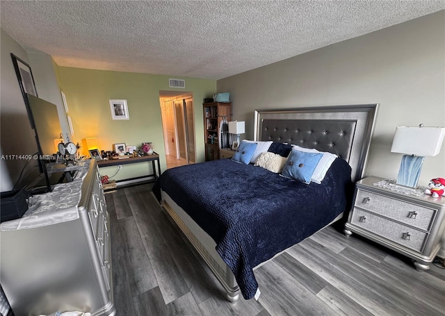 bedroom featuring dark hardwood / wood-style flooring and a textured ceiling