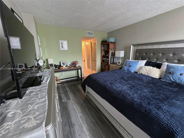 bedroom with dark hardwood / wood-style flooring and a textured ceiling