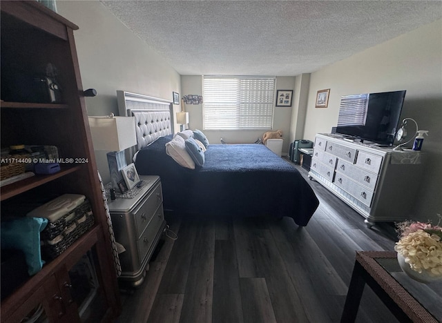 bedroom featuring dark hardwood / wood-style flooring and a textured ceiling