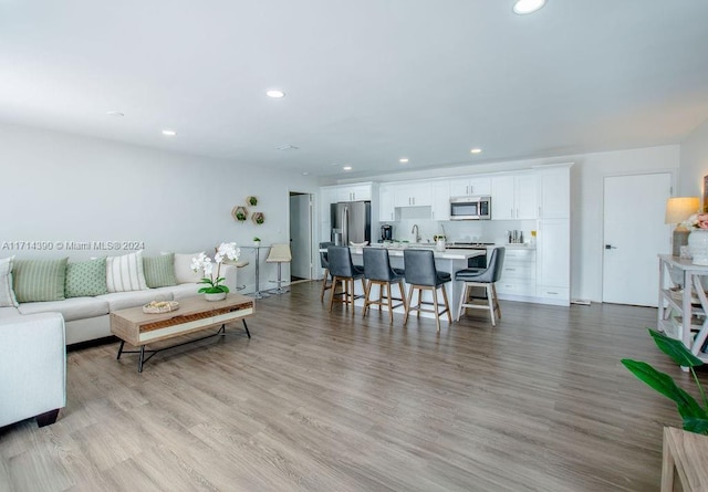 living room featuring light wood-type flooring and sink