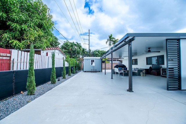 view of patio / terrace with an outdoor living space, a shed, and ceiling fan