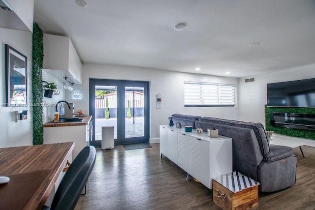 living room with dark hardwood / wood-style floors and sink