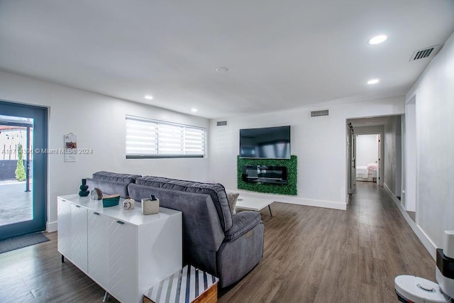 living room with dark wood-type flooring and a healthy amount of sunlight