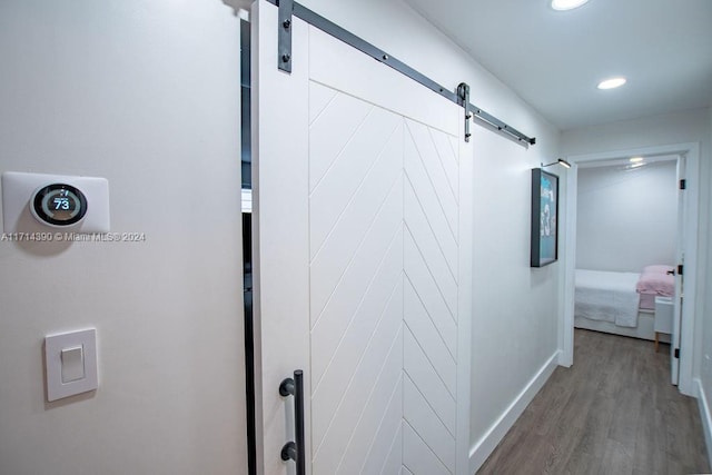 corridor featuring a barn door and dark hardwood / wood-style floors