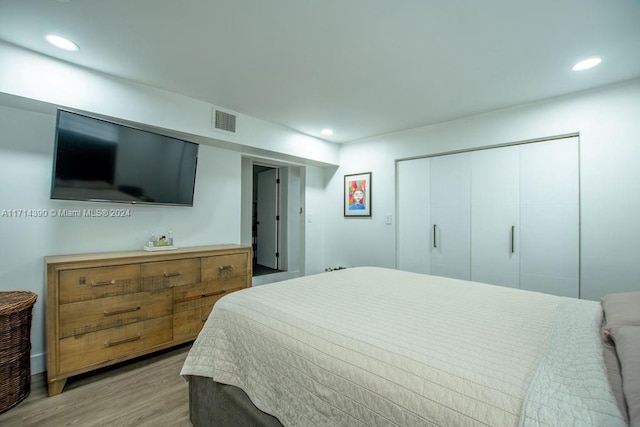 bedroom with light wood-type flooring and a closet