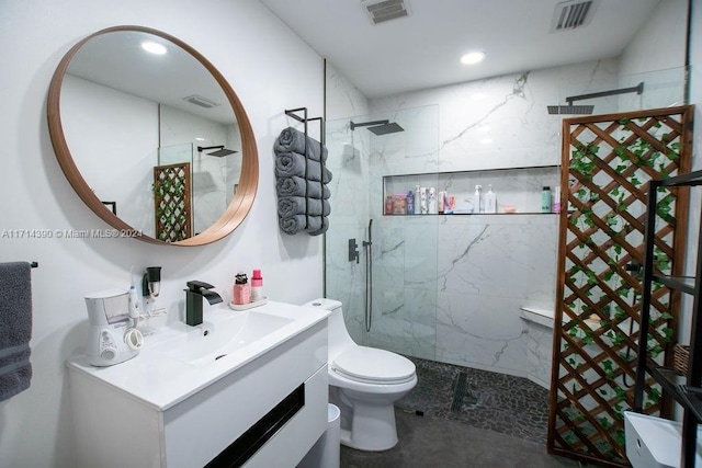 bathroom featuring vanity, toilet, and a tile shower