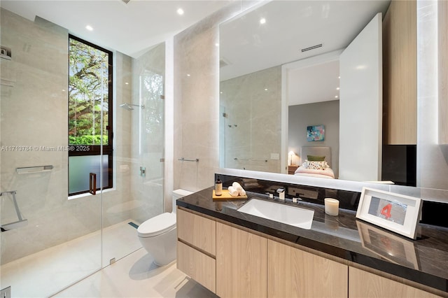 bathroom with walk in shower, vanity, toilet, and tile walls