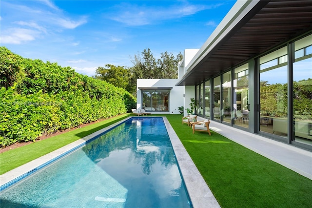 view of swimming pool featuring a yard