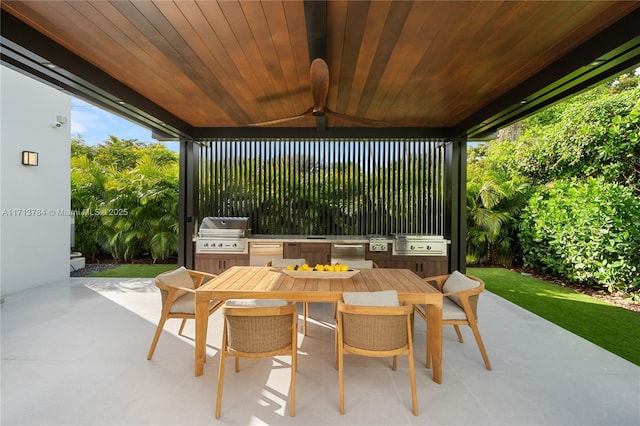 view of patio featuring a grill, ceiling fan, and an outdoor kitchen