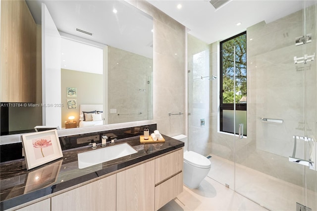 bathroom featuring a shower with door, tile patterned flooring, vanity, expansive windows, and toilet