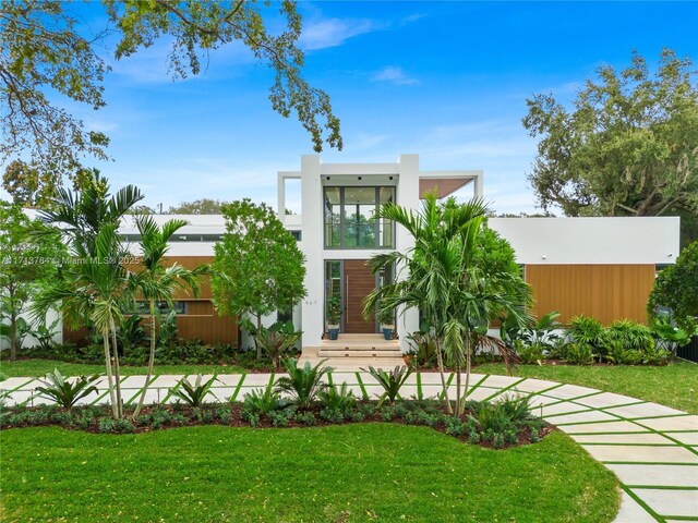 contemporary house with a balcony and a front lawn