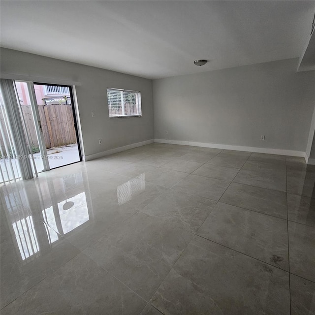 empty room with tile patterned flooring and baseboards