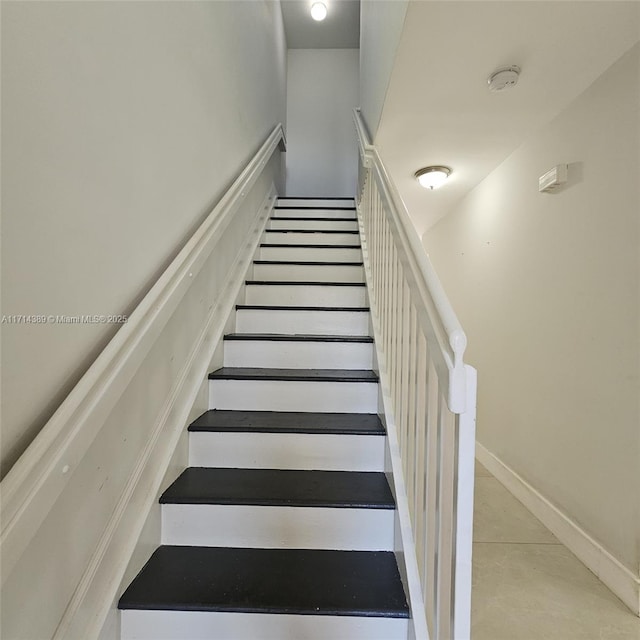 staircase featuring baseboards