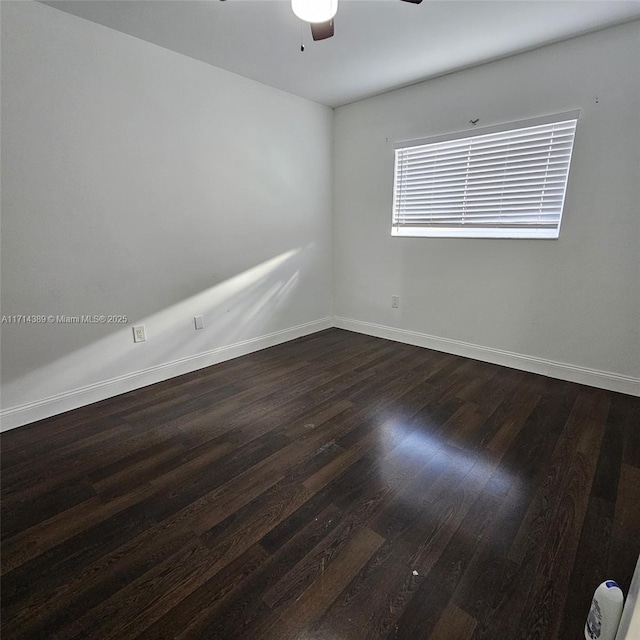 unfurnished room featuring baseboards, dark wood finished floors, and a ceiling fan