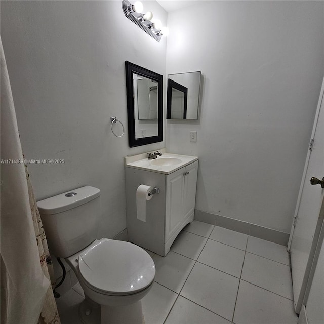 bathroom featuring toilet, vanity, baseboards, and tile patterned floors