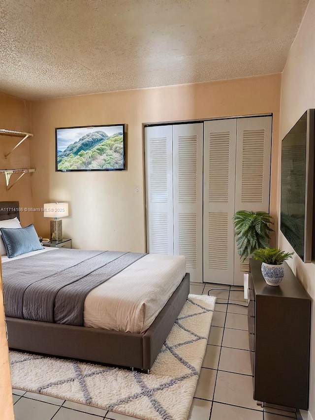 tiled bedroom featuring a closet and a textured ceiling