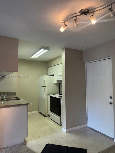 kitchen featuring white cabinets, white appliances, and sink