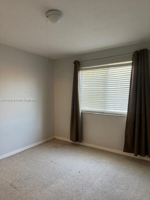 unfurnished room with light colored carpet