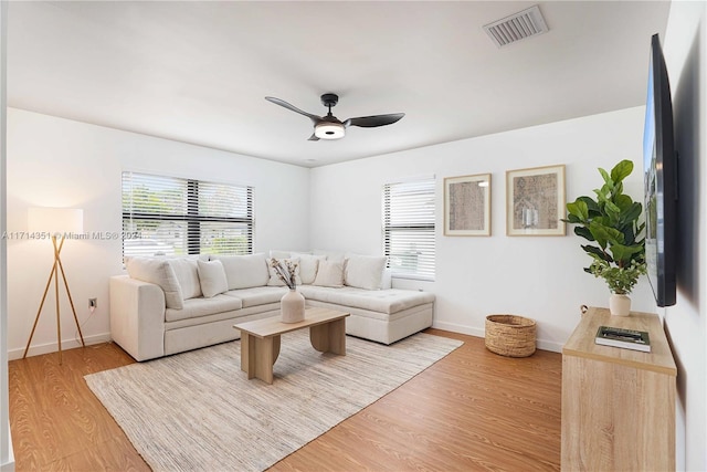 living room with light hardwood / wood-style flooring and ceiling fan