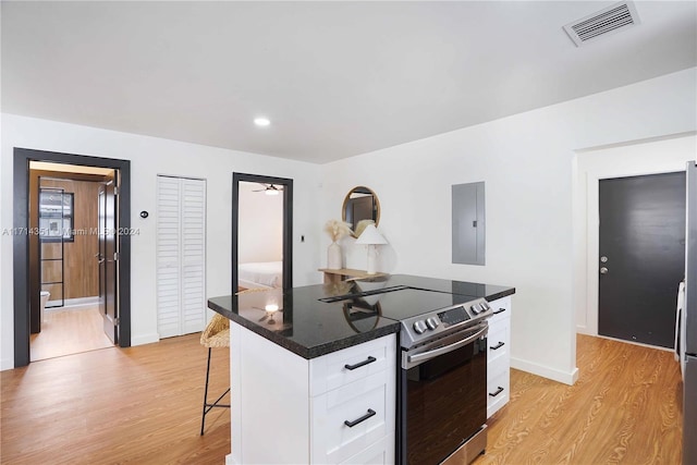 kitchen with white cabinetry, light hardwood / wood-style flooring, electric panel, a breakfast bar, and stainless steel range with electric cooktop