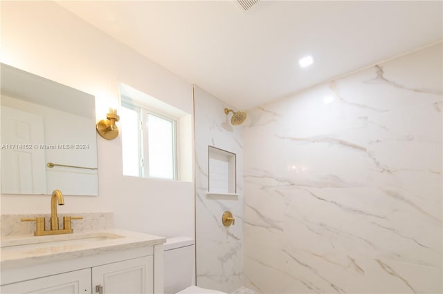 bathroom featuring vanity, toilet, and a tile shower