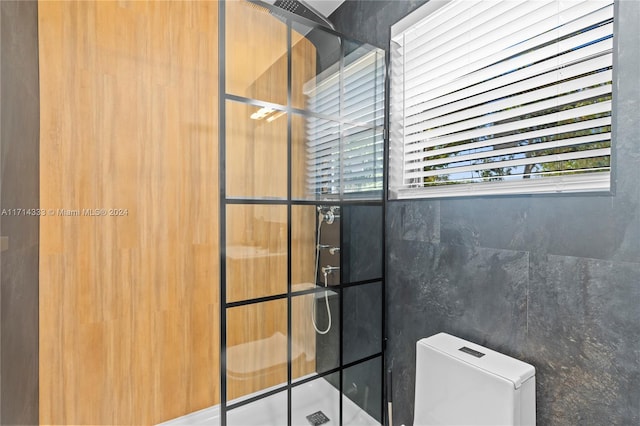 bathroom with toilet and a shower with door