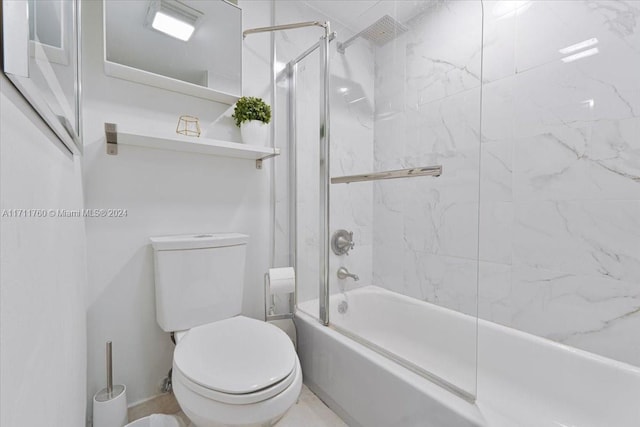 bathroom featuring enclosed tub / shower combo and toilet