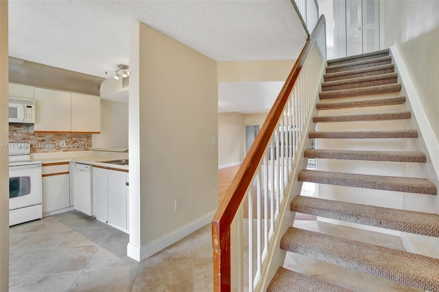 stairway with sink and tile patterned flooring