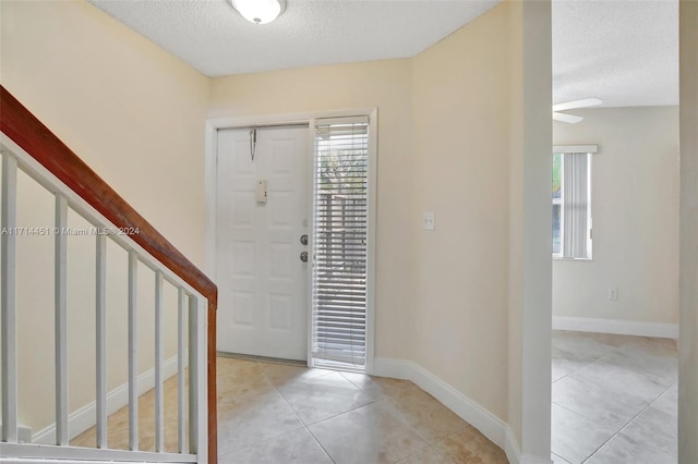 tiled entrance foyer featuring a textured ceiling