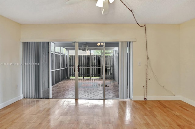 empty room featuring ceiling fan, a textured ceiling, and hardwood / wood-style flooring