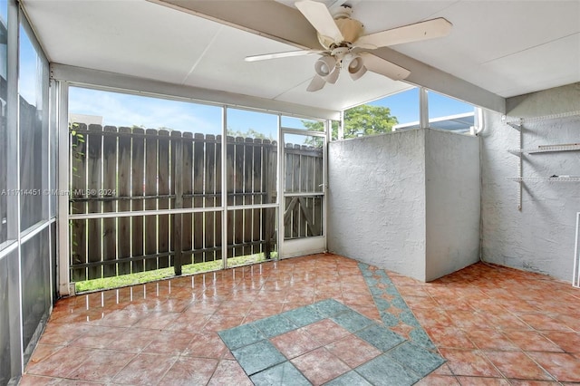 unfurnished sunroom with ceiling fan