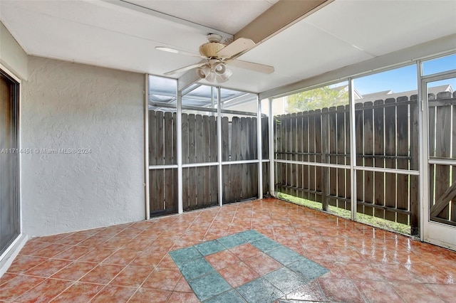 unfurnished sunroom with ceiling fan