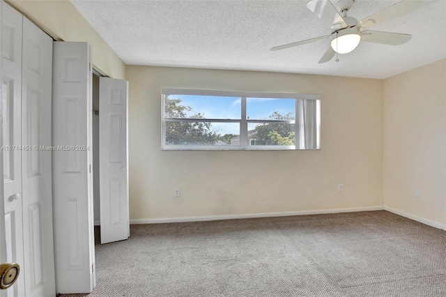 unfurnished bedroom with ceiling fan, carpet floors, and a textured ceiling