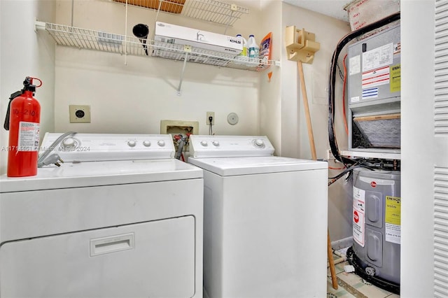 clothes washing area featuring washing machine and dryer and water heater