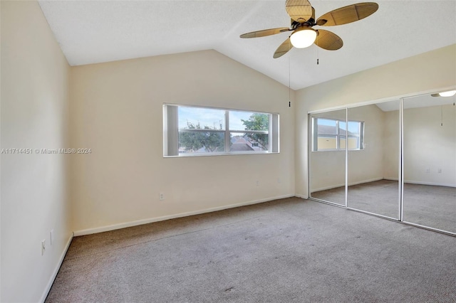 unfurnished bedroom featuring ceiling fan, carpet, a closet, and vaulted ceiling