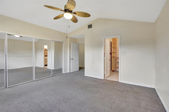 unfurnished bedroom featuring ceiling fan, light colored carpet, ensuite bath, and vaulted ceiling