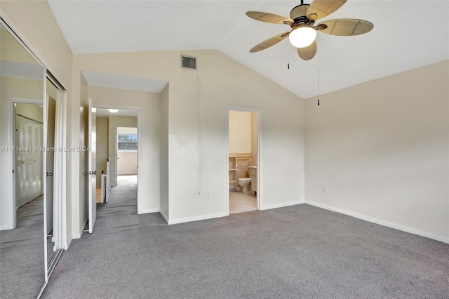 unfurnished bedroom featuring ceiling fan, carpet, connected bathroom, a closet, and vaulted ceiling