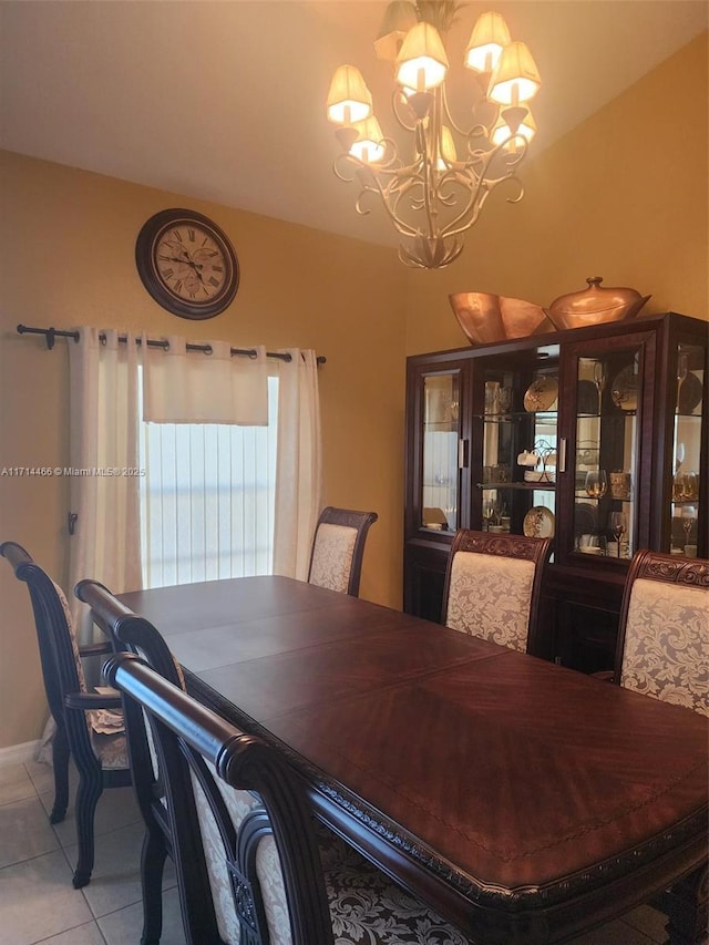 tiled dining room featuring an inviting chandelier