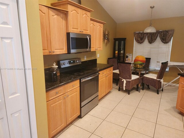 kitchen with light brown cabinets, hanging light fixtures, dark stone countertops, light tile patterned flooring, and stainless steel appliances