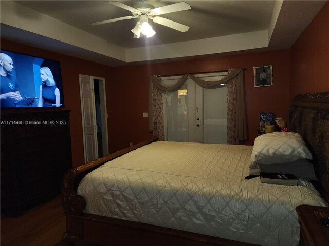 bedroom featuring a raised ceiling and ceiling fan