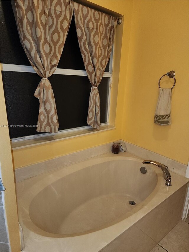 bathroom featuring tile patterned flooring and tiled bath