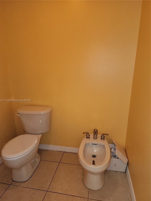 bathroom with tile patterned flooring, a bidet, and toilet