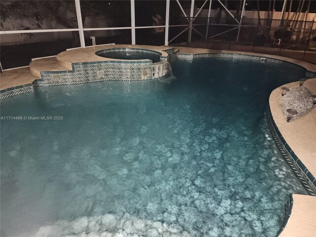 view of swimming pool featuring an in ground hot tub