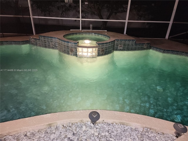 view of swimming pool featuring an in ground hot tub and a lanai