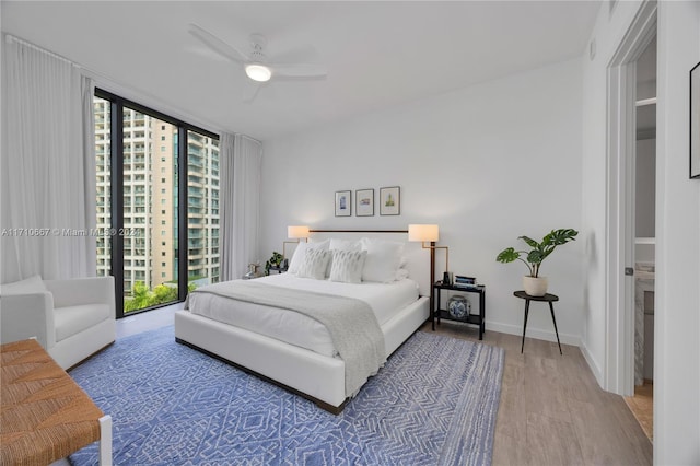 bedroom featuring hardwood / wood-style floors, ceiling fan, access to exterior, and multiple windows