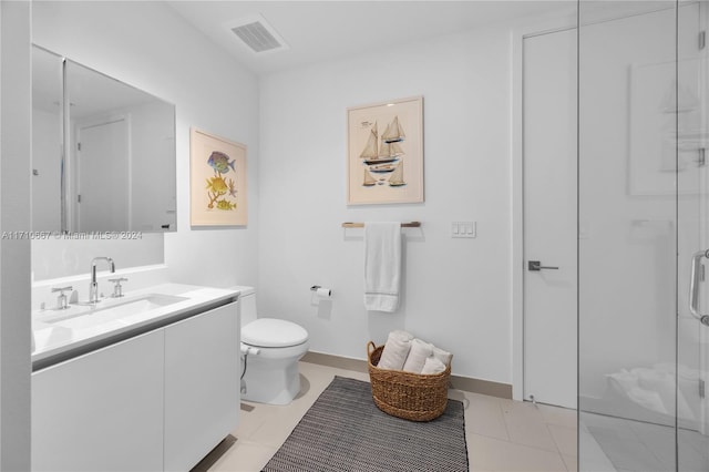 bathroom featuring tile patterned flooring, vanity, toilet, and walk in shower